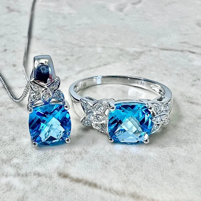 Conjunto de anillo y collar con colgante de topacio azul suizo y diamantes en oro blanco de 14 quilates.